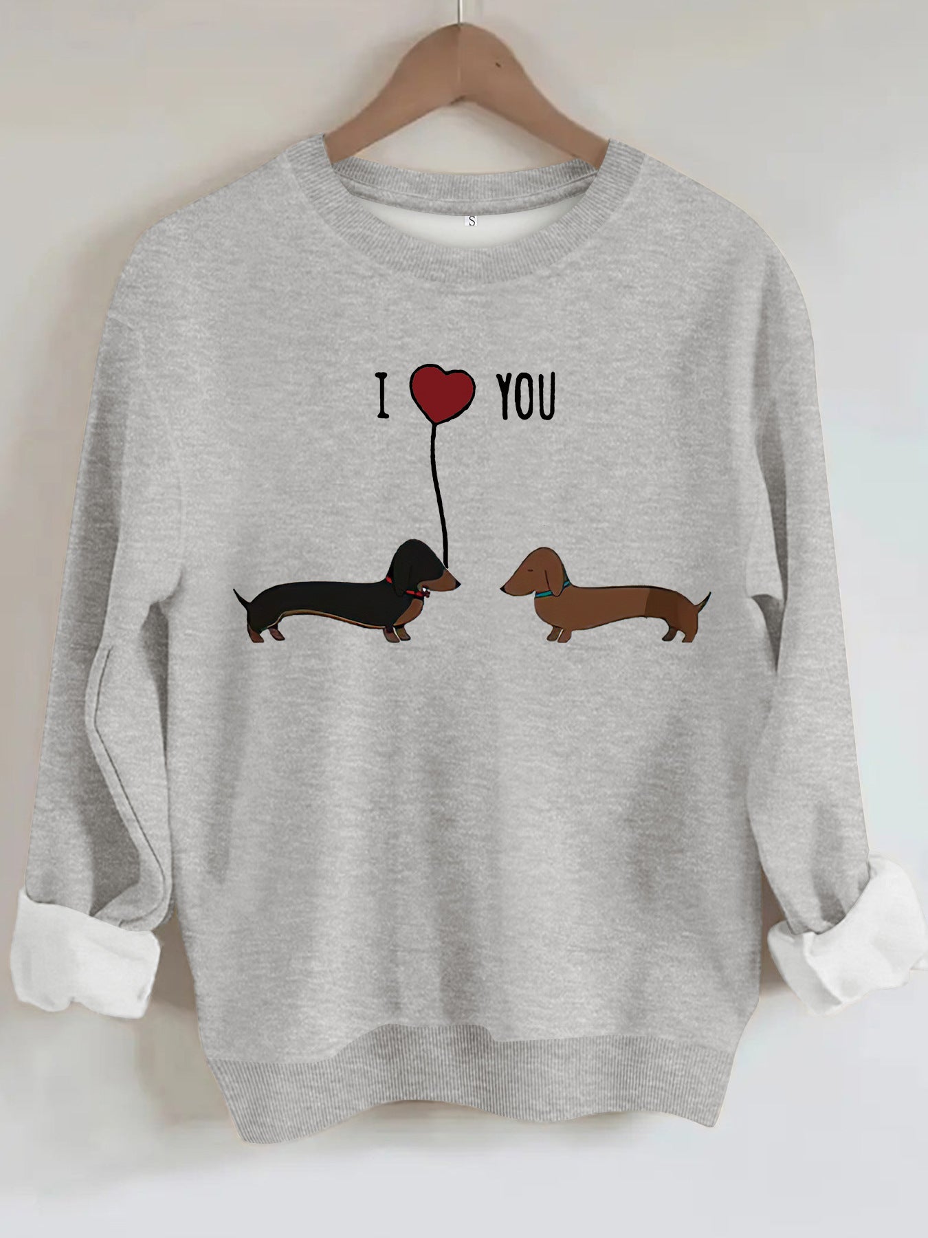 Two dog print hoodies featuring dachshunds with a heart graphic on a gray sweater.