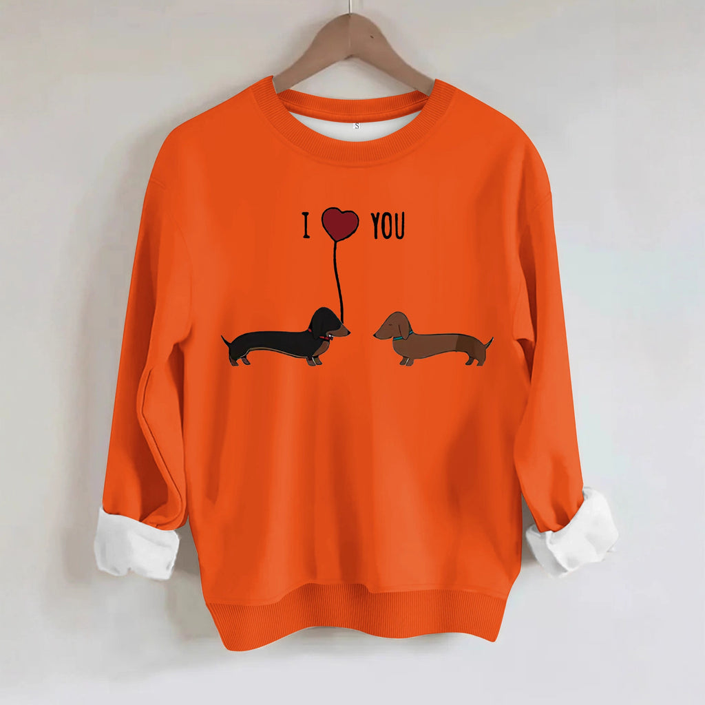 Two dog print hoodies featuring black and brown dachshunds with 'I love you' text on an orange sweatshirt.