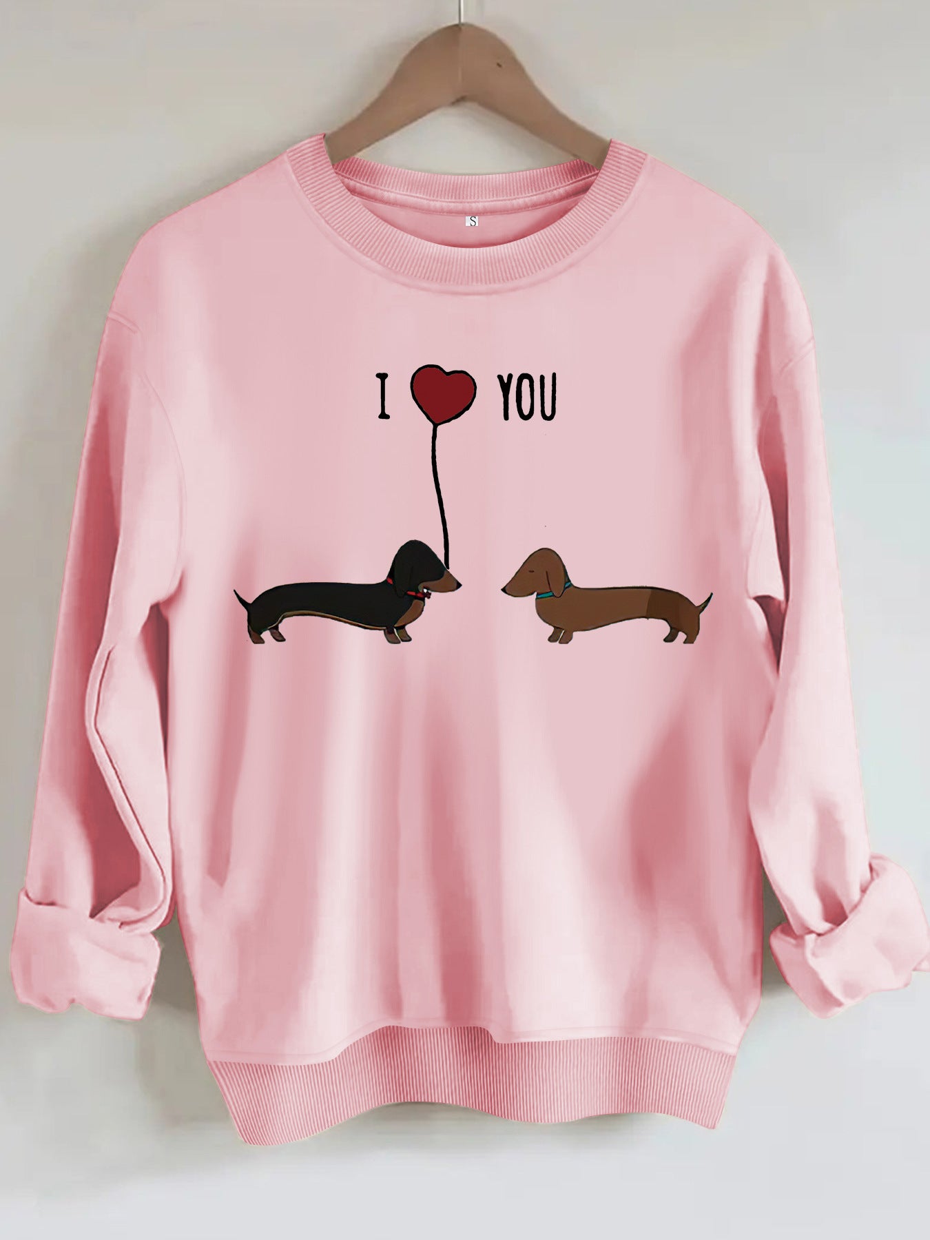 Two dog print hoodies featuring cute dachshund graphics on a pink sweatshirt.