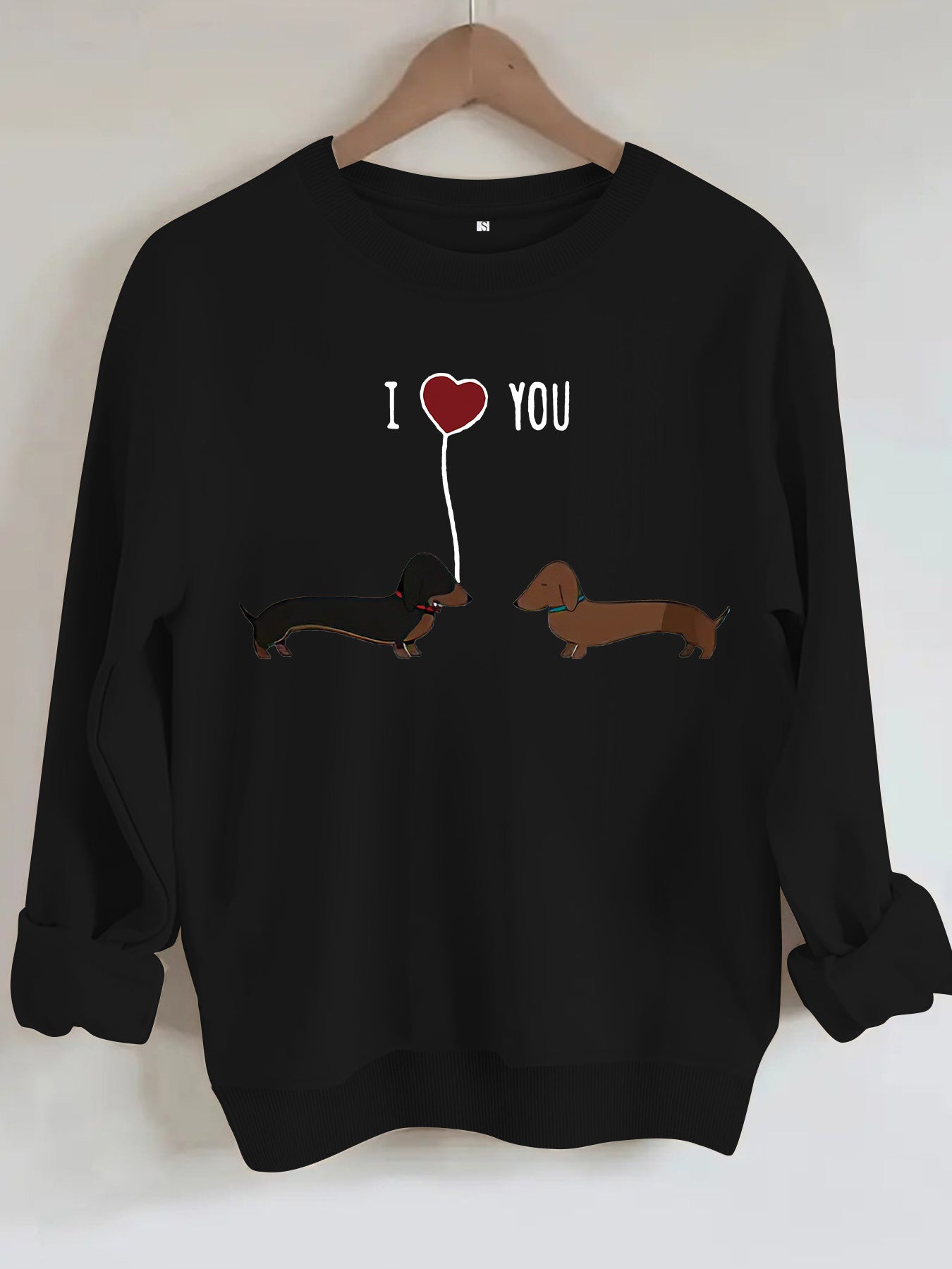 Two dog print hoodies featuring cute dachshund illustrations and a heart design in a stylish black sweatshirt.