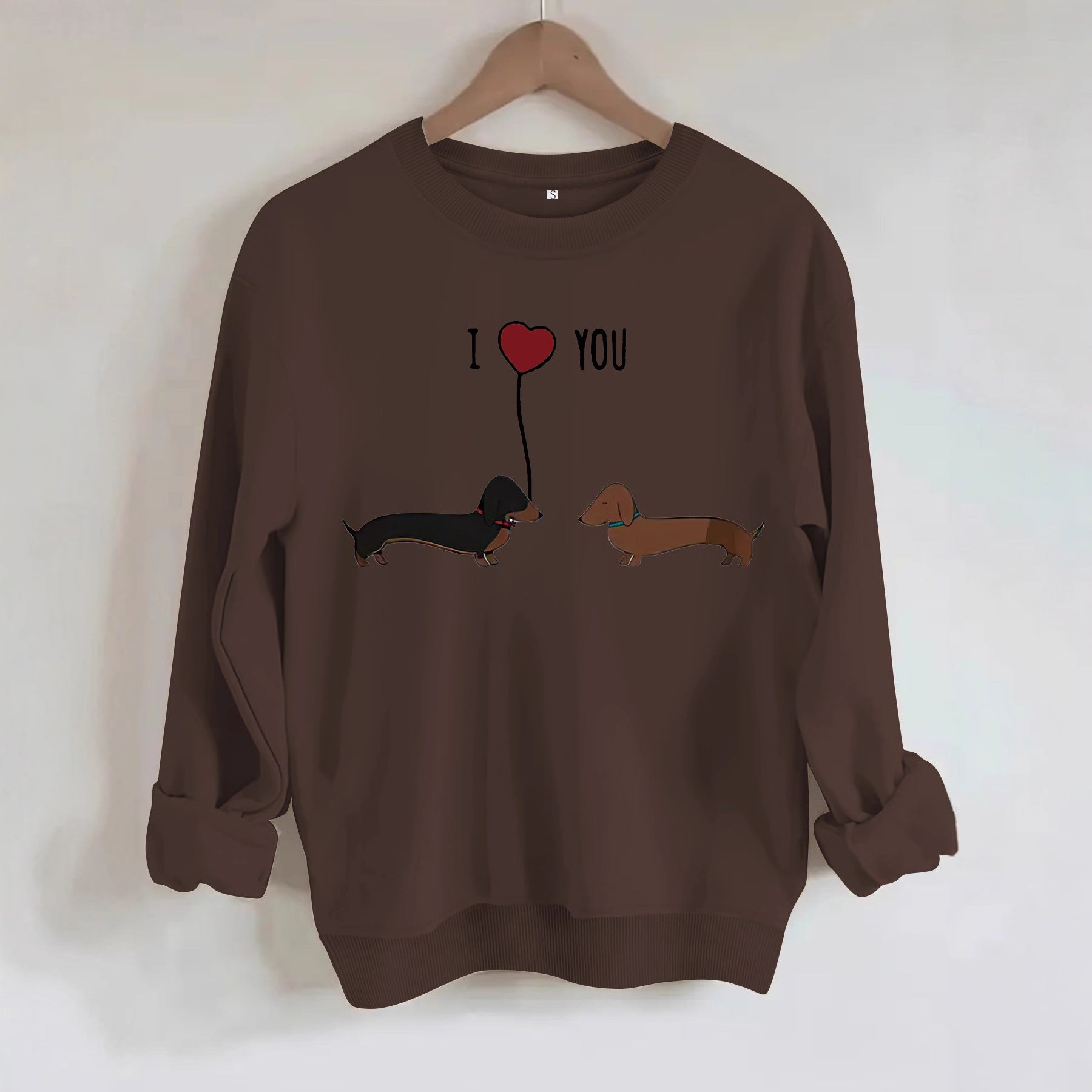 Two dog print hoodies featuring dachshund design with 'I ❤️ YOU' text on a brown background.